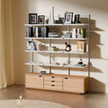 Adjustable modular metal shelves in use as a bookshelf with decorative items against a beige wall