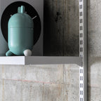 Close-up of steel shelf and bracket connection on modular wall shelving system