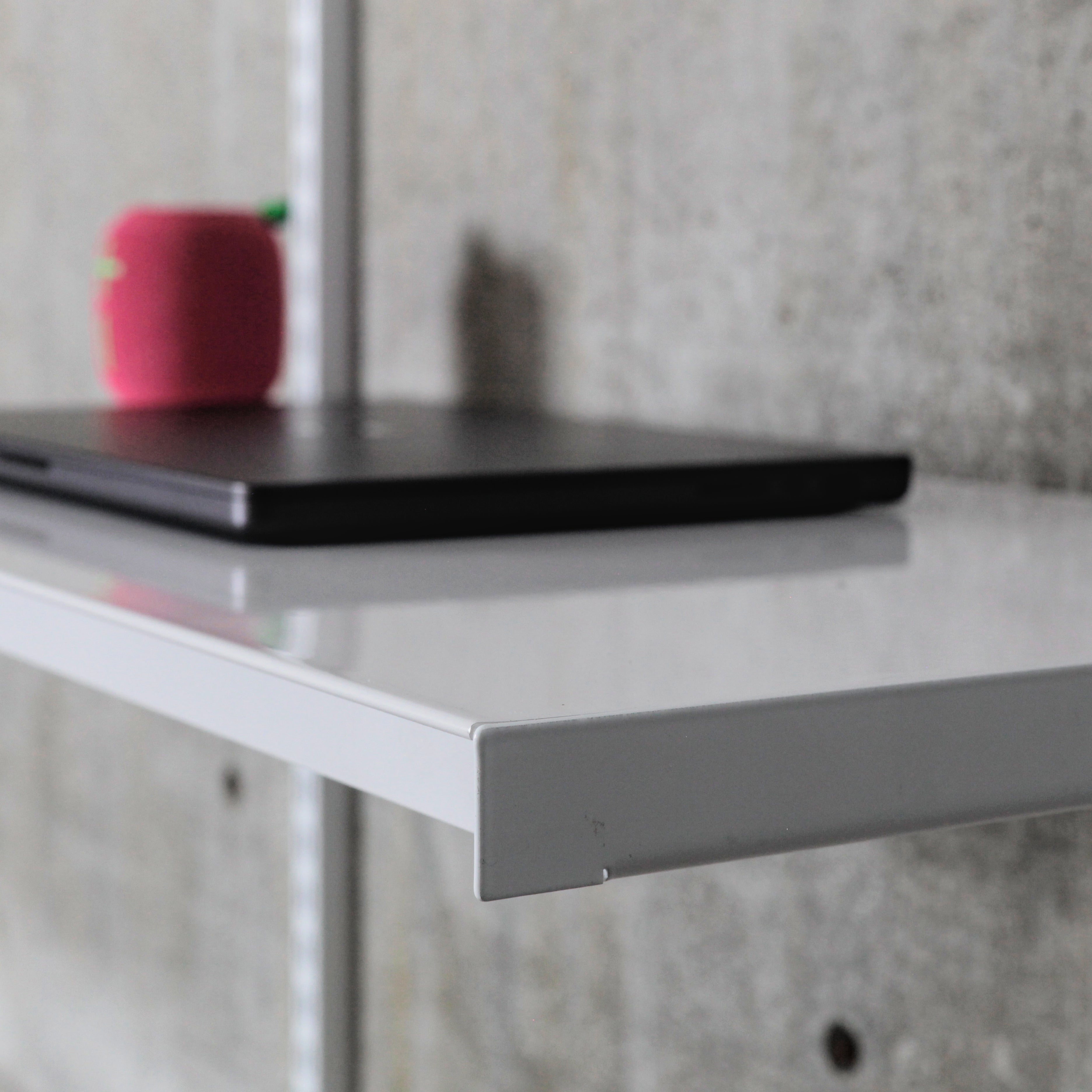 Close-up of steel shelf front edge showing folded lip and powder-coated finish
