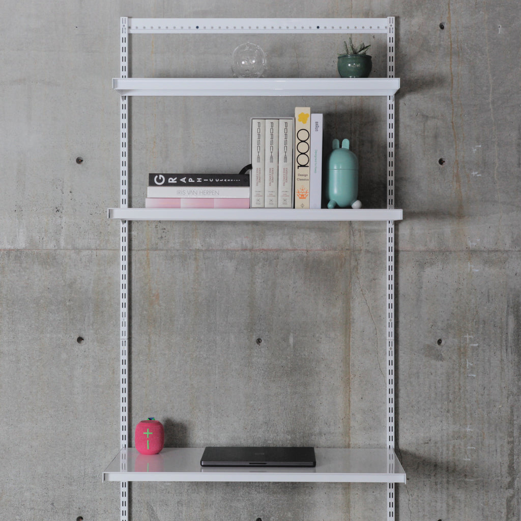 Modular wall-mounted shelving system with three steel shelves, books above and laptop on lower shelf