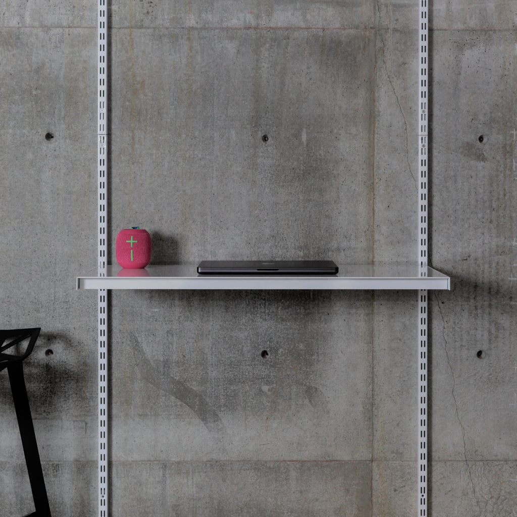 Wall-mounted steel shelf with speaker and laptop on modular shelving system